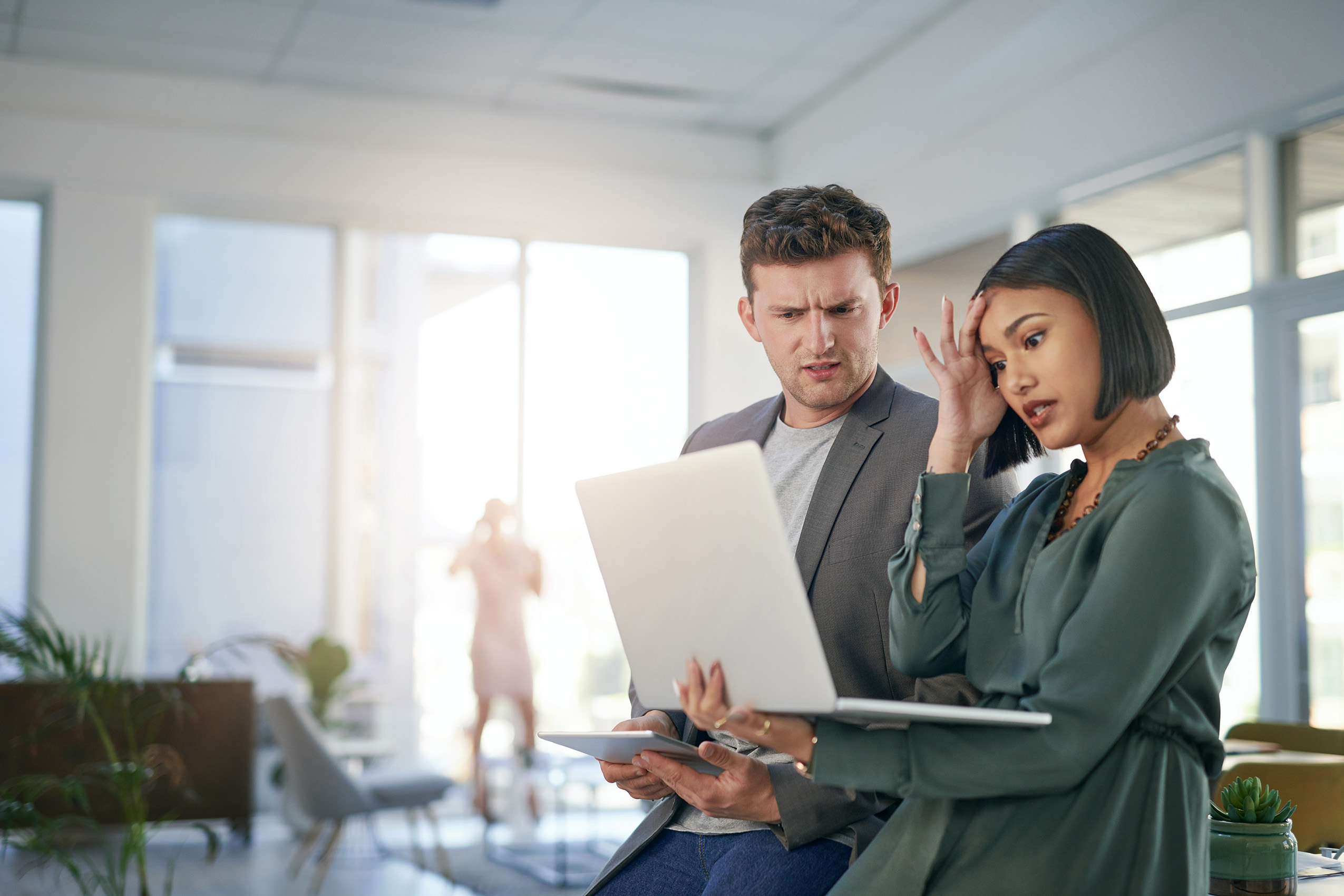 man and woman looking confused with laptop