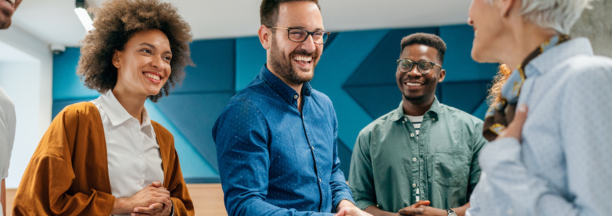 New hire shaking hands and meeting smiling coworkers.