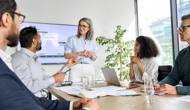 Female leader talking to employees in a conference room. 