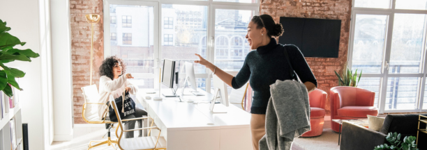 Woman waving goodbye to a coworker at the end of the work day.