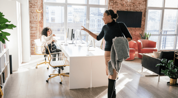 Woman waving goodbye to a coworker at the end of the work day.