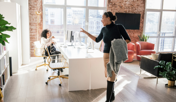 Woman waving goodbye to a coworker at the end of the work day.