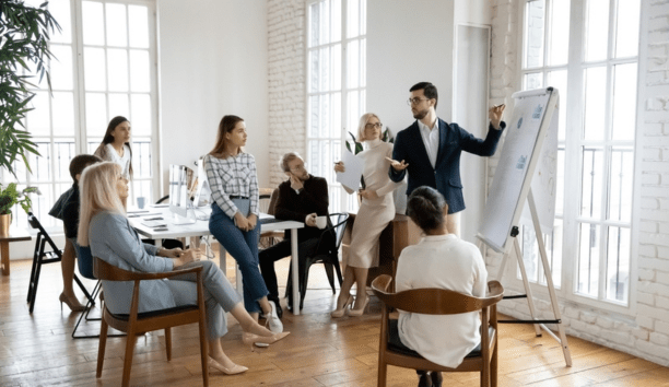 Group of employees of all ages working in a conference room together.